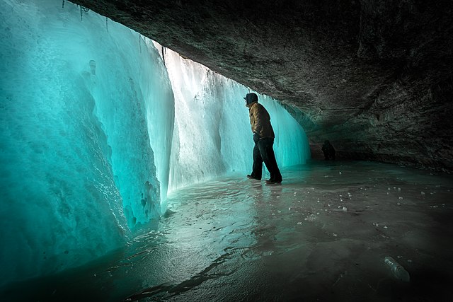 Photo of man behind frozen waterfall at Minnehaha Falls in Minneapolis, Minnesota. Author: Lorie Shaull.